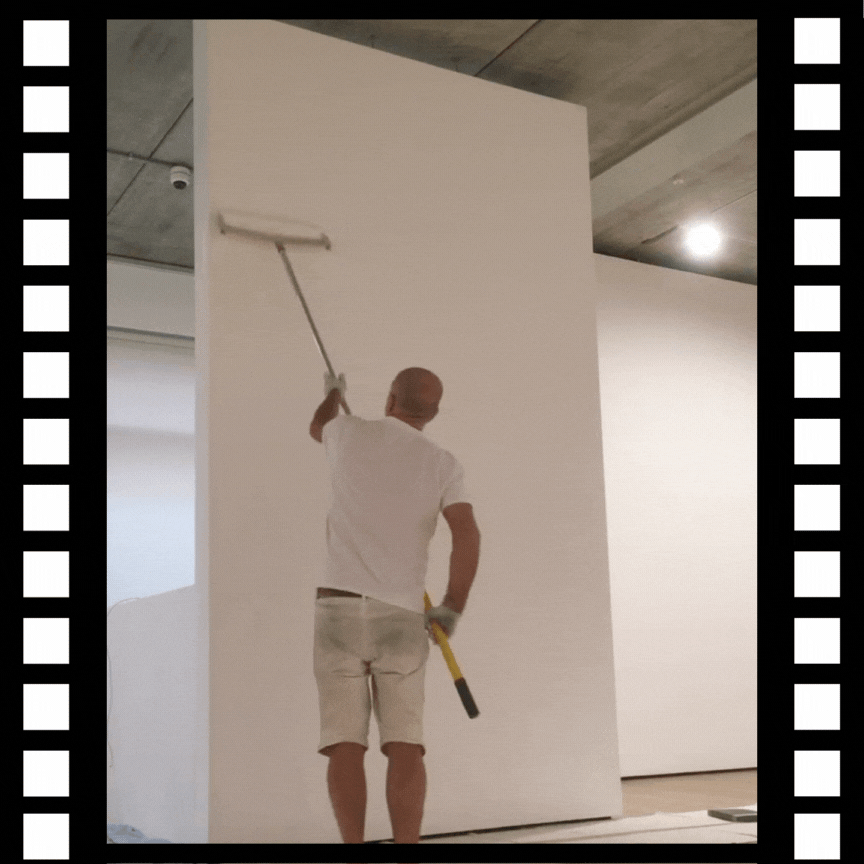 Central London Painter Decorator Andrew Gard, painting a white wall with a roller