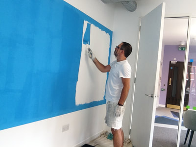 A blue dry erase board area being created with a specialists paint system creating a creative drawing and writing area in an office in Fitzrovia
