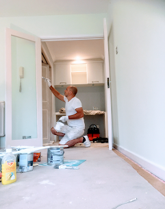 Painter decorator painting a door in central london