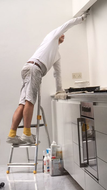 Painter Andrew on a step ladder painting in central London
