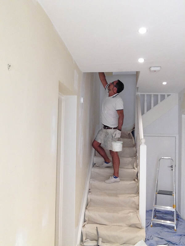 Painter painting walls in a stairway