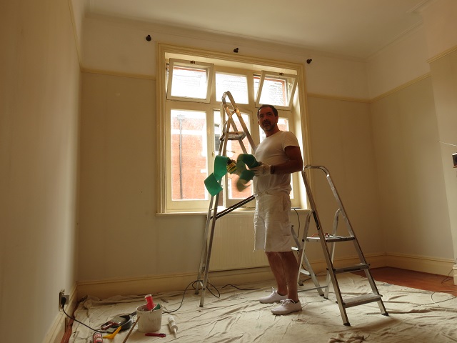 Painter in Marylebone painting a room with sandpaper, ladder and dustsheets